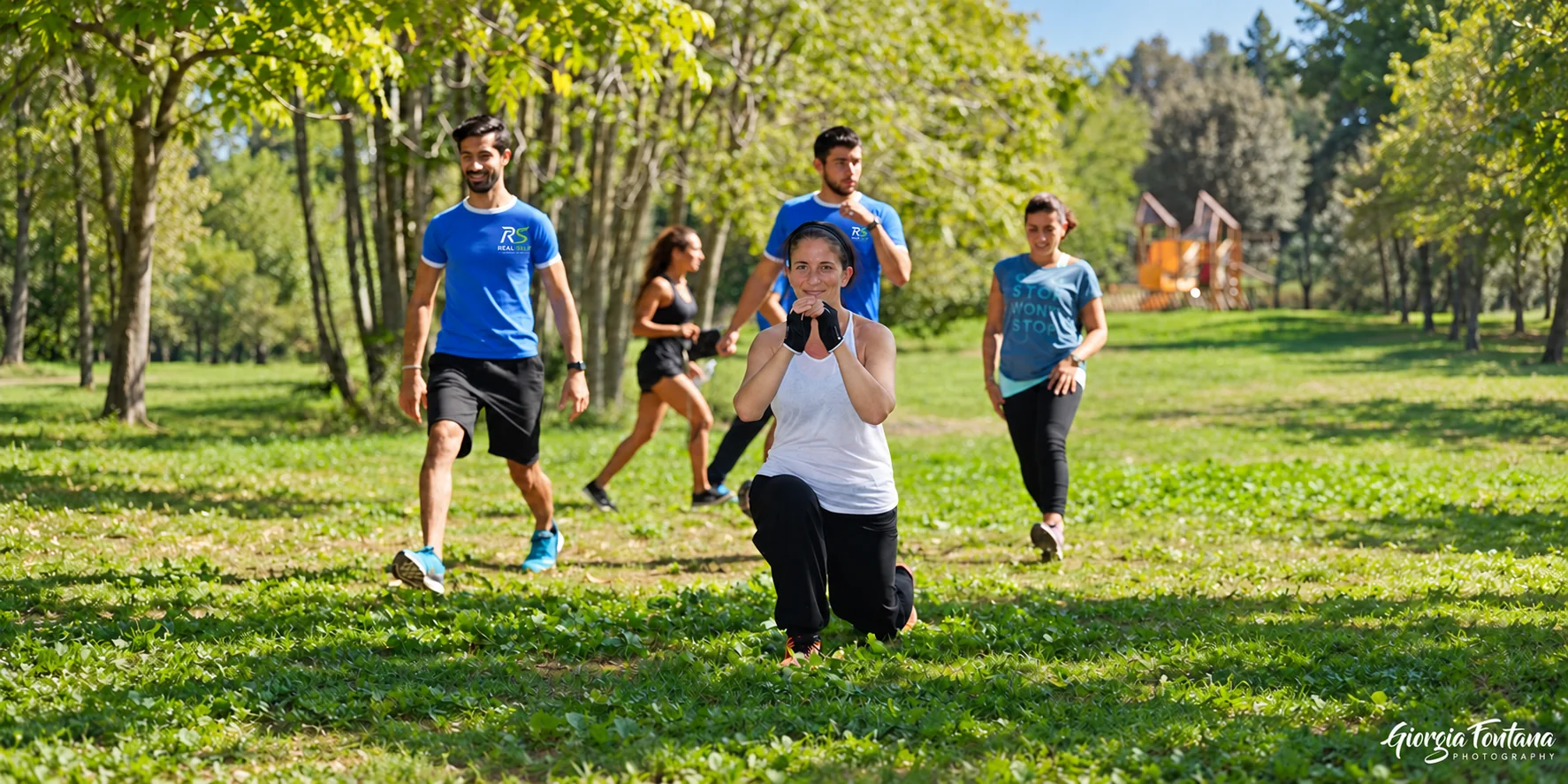 Allenamento di gruppo all’aperto con esercizi a corpo libero nel parco